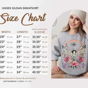 May include: Size chart for a unisex Gildan sweatshirt with measurements in inches and centimeters. The chart shows the width, length, and sleeve length for sizes S through 5XL. The chart also includes a note about size tolerance.