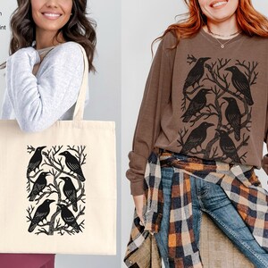 May include: A cream-colored tote bag with a black raven design and the text "15 x 16 Cotton Tote Bag One Sided Print". A brown long-sleeve shirt with a raven graphic is also shown. The shirt is labeled "Espresso".