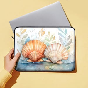 May include: A laptop sleeve with a watercolor design of two seashells in a bed of seaweed and bubbles. The seashells are orange, pink, and white.