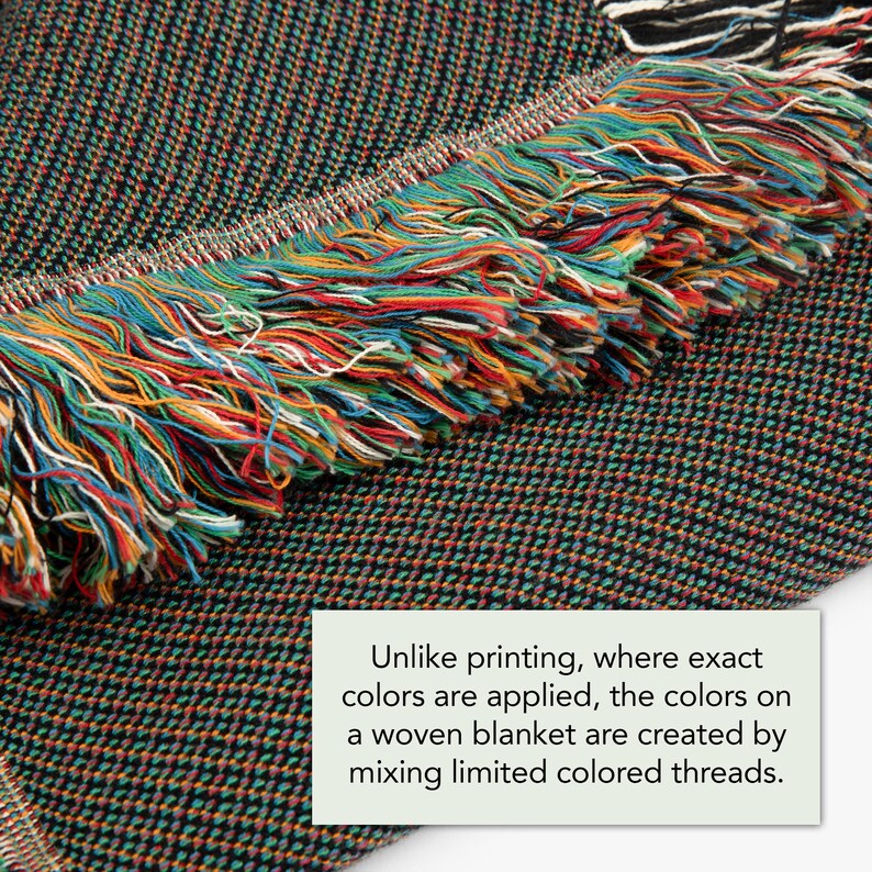 May include: Close-up of a woven blanket with a fringe edge. The blanket is made with a variety of colors, including black, green, red, orange, and yellow. "Unlike printing, where exact colors are applied, the colors on a woven blanket are created by mixing limited colored threads."