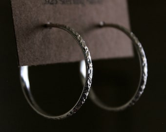 Op de afbeelding: Een paar zilveren creolen met een getextureerd ontwerp. De oorbellen zijn van 925 sterling zilver.