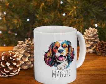 May include: White ceramic mug with a colorful illustration of a Cavalier King Charles Spaniel dog with the name "Maggie" printed below the image.