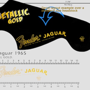 Może przedstawiać: Czarna kalkomania na główkę gitary ze złotym napisem "METALLIC GOLD" i "Fender JAGUAR". Układ kalkomanii ma szerokość 19,78 cm i jest przykładem na standardowej główce. Wydrukowano również "Jaguar 1965 ALL GOLD".