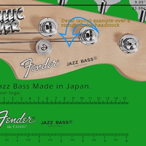 Könnte beinhalten: Nahaufnahme einer Fender Jazz Bass Kopfplatte mit silberfarbener Hardware. Der Text "METALLIC SILVER" ist sichtbar. Die Kopfplatte ist 23.00 cm breit. Der Text "Jazz Bass Made in Japan" und das Fender-Logo sind ebenfalls sichtbar.