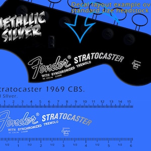 Puede incluir: Calcomanía negra para la pala de guitarra con texto "METALLIC SILVER". Presenta el logotipo "Fender Stratocaster" y el texto "Stratocaster 1969 CBS". Incluye reglas en pulgadas y centímetros. El ejemplo de diseño es para una pala de tamaño estándar.