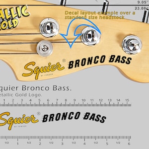 May include: A close-up of a bass guitar headstock with the "Squier Bronco Bass" logo in black and gold. The image includes measurements of 9.05 inches and 23.00 cm, along with a decal layout example.