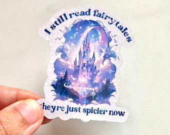 May include: A clear sticker with a fairytale castle design, featuring a blue and purple color scheme with stars and clouds. The text reads "I still read fairytales, they're just spicier now."