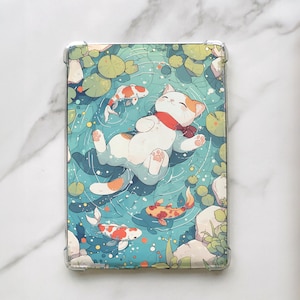 May include: A white cat with orange markings floats on its back in a blue pond with green lily pads. The cat has a red scarf around its neck and is surrounded by orange and white fish.