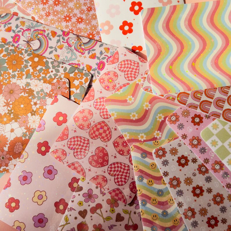 Puede incluir: Un conjunto de 10 hojas de papel de scrapbooking con patrones de estilo vintage. Los papeles presentan una variedad de dise&ntilde;os, incluyendo corazones, flores, arco&iacute;ris y patrones geom&eacute;tricos. Los colores son principalmente rosa, naranja y blanco.