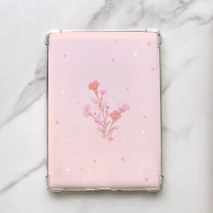 Puede incluir: Una funda de tel&eacute;fono rosa con un dise&ntilde;o floral y detalles plateados. Las flores son rosas y naranjas con detalles blancos. El fondo es rosa claro con estrellas blancas.