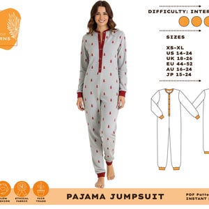 Könnte beinhalten: Eine Frau trägt einen grauen Pyjama-Overall mit roten Verzierungen und kleinen roten Baummotiven. Das Design hat eine Knopfleiste vorne und lange Ärmel. Das Bild enthält auch eine Musterzeichnung und den Text "PAJAMA JUMPSUIT".