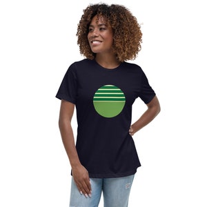 May include: A navy blue t-shirt with a green and yellow circle design. The circle has a green top half with four yellow stripes and a green bottom half.