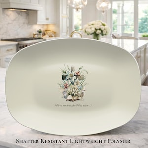 May include: Off-white, rectangular serving platter with a floral and cross design. The design features a cross adorned with lilies and other flowers, with the text "He is not here, for He is risen..." printed below. The platter is made of shatter-resistant, lightweight polymer.