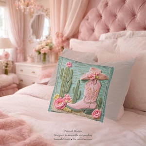 May include: A square throw pillow featuring a printed design that resembles embroidery. The image displays a light pink cowboy boot and a matching hat adorned with flowers, set against a light blue background with green cacti and pink flowers.