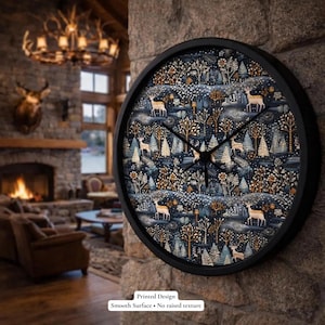 May include: A round black wall clock with a forest scene design featuring deer, trees, and snow. The clock face has a dark blue background with white, gold, and brown accents. The text "Printed Design" and "Smooth Surface • No raised texture" are at the bottom.