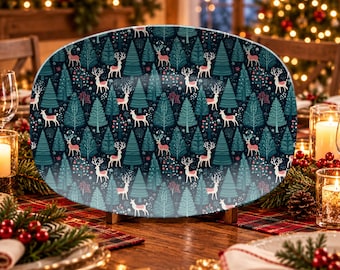 May include: An oval serving platter featuring a repeating pattern of white deer with antlers and stylized teal and dark green evergreen trees against a dark navy blue background. The platter has a smooth, glossy finish and a wide, flat surface.
