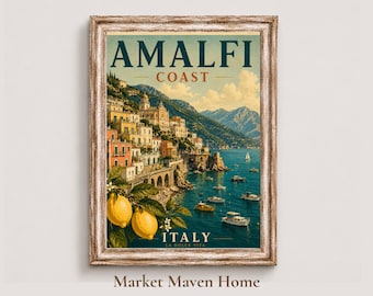 May include: A framed wall art print featuring a coastal landscape of the Amalfi Coast in Italy. The image displays colorful hillside buildings, blue water with small boats, and two yellow lemons in the foreground. The text reads AMALFI COAST.