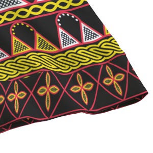 May include: Close-up of a black fabric with a repeating pattern. The design features yellow, red, and white geometric shapes, including triangles, diamonds, and floral motifs. The edges are trimmed with a red border.