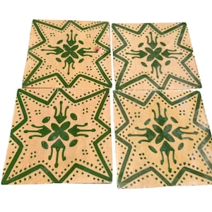 May include: Four square ceramic tiles with a beige background and a green starburst design. Each tile features a central floral motif and dotted border, creating a decorative pattern. The tiles are arranged together, showcasing the repeating design.