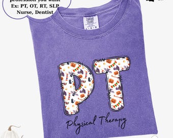 May include: A purple t-shirt with the letters "PT" in a Halloween-themed pattern. The shirt also has the words "Physical Therapy" printed below the letters. The shirt is a Comfort Colors brand.