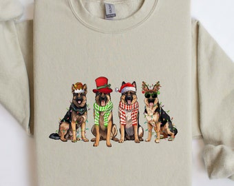 May include: A beige sweatshirt featuring a graphic of four German Shepherds dressed in festive holiday attire. Each dog is adorned with Christmas lights and accessories like hats and scarves, creating a cheerful, seasonal design.