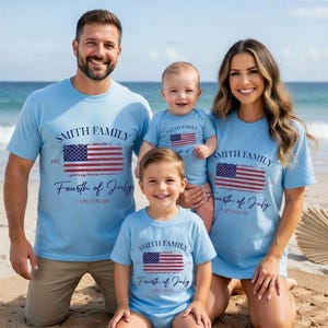 A family of four, consisting of a father, mother, and two children, posing together on a beach. They are all wearing matching t-shirts with the text "Smith Family Fourth of July Cape Cod, MA" printed on them.