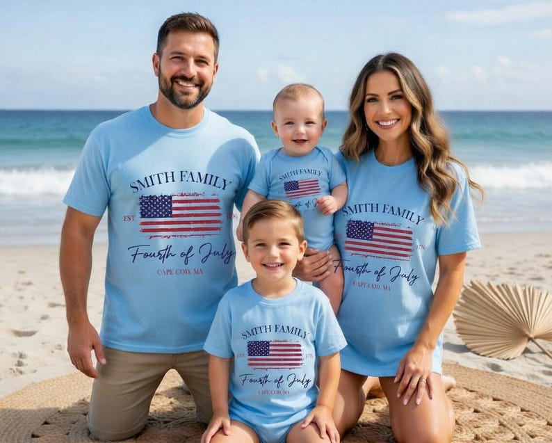 A family of four, consisting of a father, mother, and two children, posing together on a beach. They are all wearing matching t-shirts with the text "Smith Family Fourth of July Cape Cod, MA" printed on them.