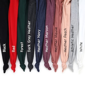 Puede incluir: Una colecci&oacute;n de camisetas dobladas en varios colores, incluyendo negro, rojo, verde bosque, gris oscuro jaspeado, azul marino jaspeado, granate jaspeado, malva jaspeado, melocot&oacute;n jaspeado, gris atl&eacute;tico jaspeado y blanco. Cada camiseta est&aacute; etiquetada con su nombre de color.