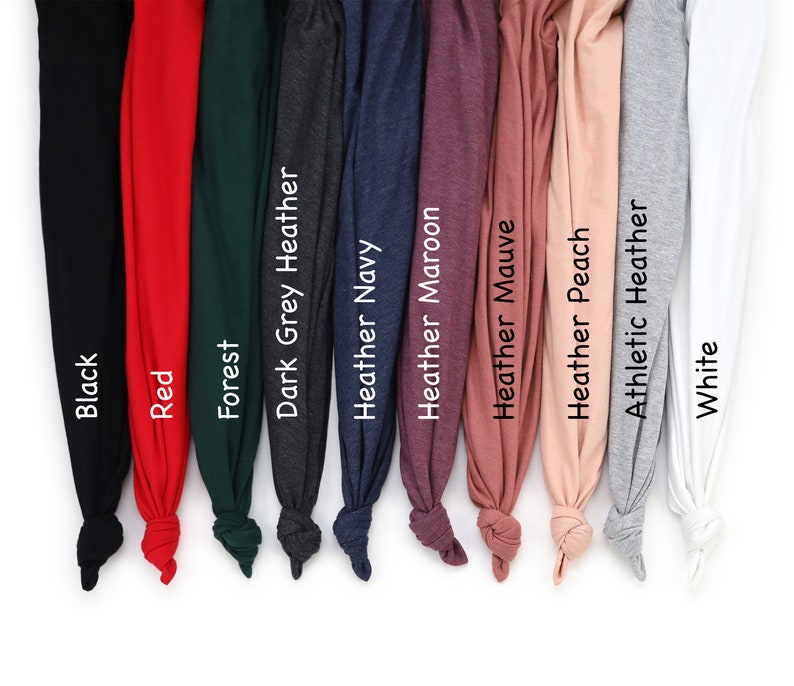 Puede incluir: Una colecci&oacute;n de camisetas dobladas en varios colores, incluyendo negro, rojo, verde bosque, gris oscuro jaspeado, azul marino jaspeado, granate jaspeado, malva jaspeado, melocot&oacute;n jaspeado, gris atl&eacute;tico jaspeado y blanco. Cada camiseta est&aacute; etiquetada con su nombre de color.