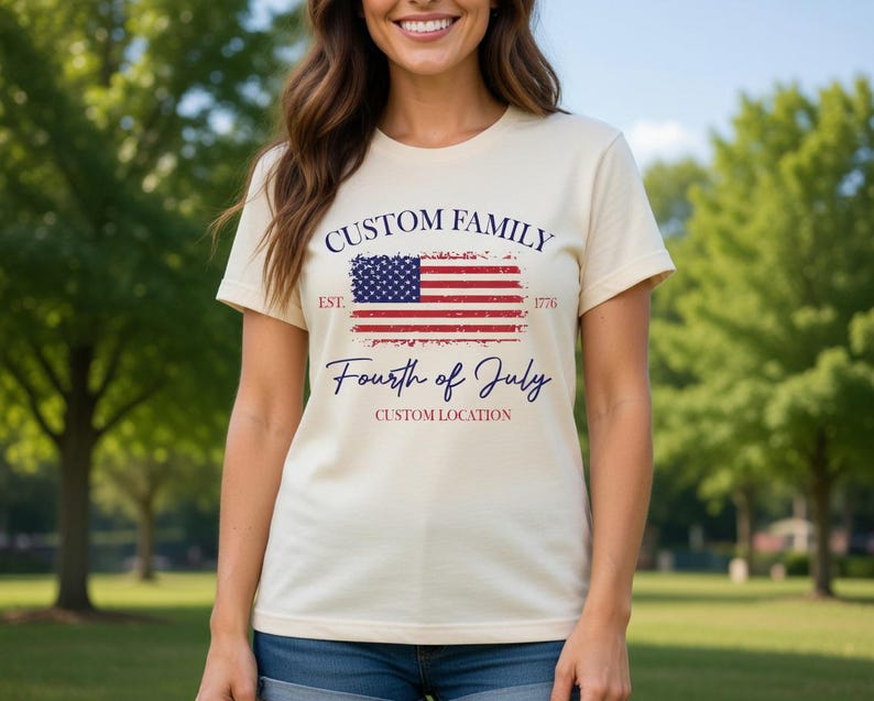 A woman wearing a white t-shirt with a graphic design featuring the American flag and the text "Custom Family" and "Fourth of July Custom Location" printed on it.