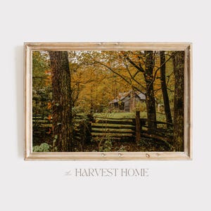 May include: A rustic wooden cabin nestled in a forest with vibrant autumn foliage. A wooden fence runs in front of the cabin, with trees and leaves in the foreground. The text "the HARVEST HOME" is visible at the bottom of the image.
