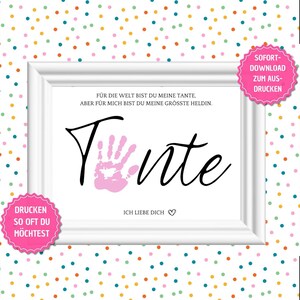 Puede incluir: Descarga digital imprimible de una impresión enmarcada con una huella de mano rosa y la palabra "Tante" en cursiva negra. El texto dice "Para el mundo eres mi tía, pero para mí eres mi mayor heroína. Te quiero." La impresión está rodeada de un marco blanco y un fondo de lunares de colores.