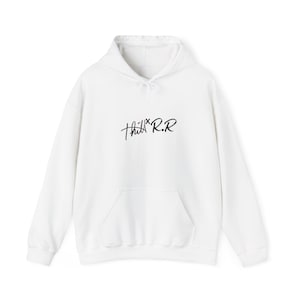 Könnte beinhalten: Ein weißer Kapuzenpullover mit langen Ärmeln, einer Kängurutasche auf der Vorderseite und einer Kapuze mit Kordelzug. In der Mitte der Brust befindet sich der schwarze Aufdruck "thill x R.R" in einer stilisierten Handschrift.