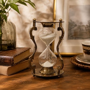 Clessidra in ottone decorata con colonne curve