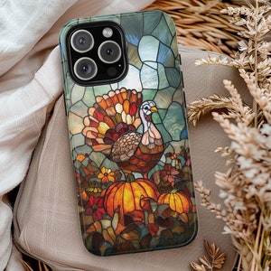 May include: A stained glass phone case featuring a colorful turkey with a red, orange, and yellow design. The turkey is surrounded by pumpkins and fall foliage.