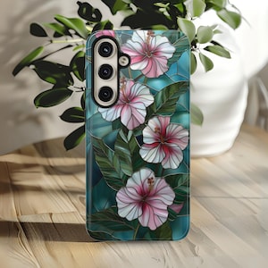 May include: A phone case with a stained glass design featuring pink and white hibiscus flowers on a teal background.
