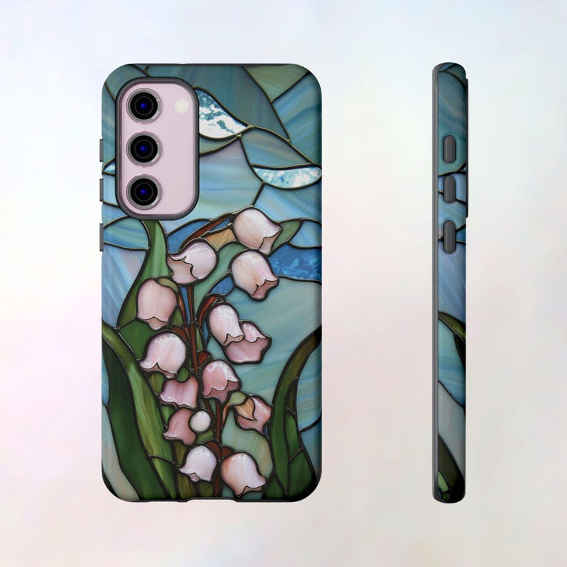 Pu&ograve; includere: Una custodia per telefono con un designo a vetri colorati che presenta un bouquet di mughetti in tonalit&agrave; rosa e bianche su uno sfondo blu e verde.