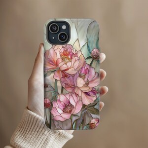 May include: A clear phone case with a stained glass design featuring pink, white, and green peonies. The case has a cutout for the phone's camera.