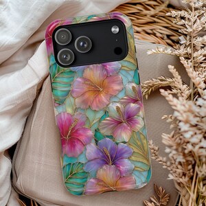 May include: A smartphone case featuring a vibrant stained-glass style pattern of pink, purple, and orange hibiscus flowers with green tropical leaves. The design includes gold-colored outlines separating the floral and leaf shapes.