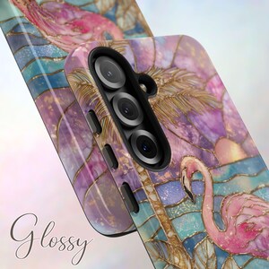 Puede incluir: Una funda brillante para tel&eacute;fono con un dise&ntilde;o de flamenco. La funda tiene un efecto de vidriera con acentos rosas, azules y dorados. La palabra "Glossy" est&aacute; escrita en cursiva en la parte inferior izquierda.