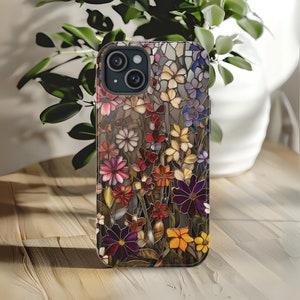 May include: A phone case with a colourful stained glass design featuring a variety of flowers in shades of red, yellow, blue, purple, and green.