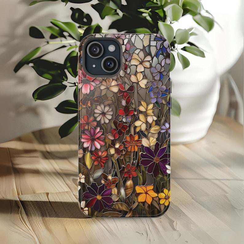 May include: A phone case with a colourful stained glass design featuring a variety of flowers in shades of red, yellow, blue, purple, and green.