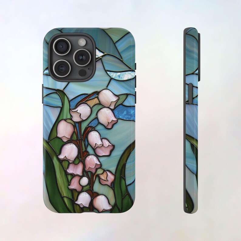 Pu&ograve; includere: Una custodia per telefono con un designo a vetri colorati che presenta un bouquet di mughetti rosa su uno sfondo blu e verde.
