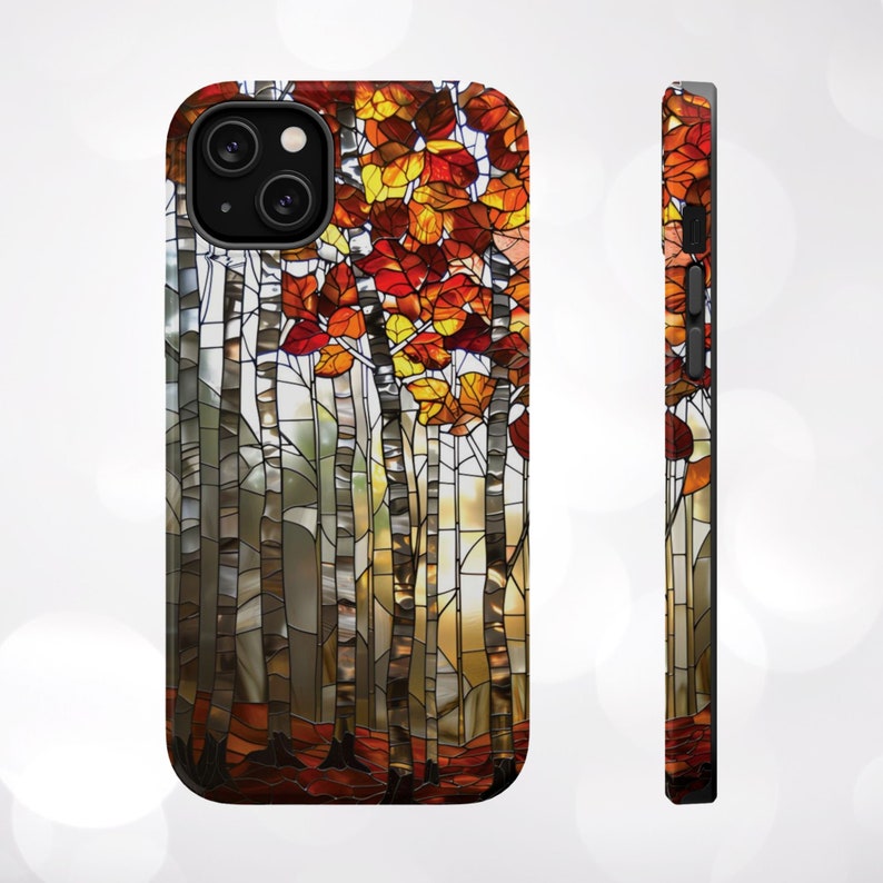 May include: A phone case featuring a stained-glass design of birch trees with autumn leaves in shades of red, orange, and yellow. The case has a black camera module and a black frame.