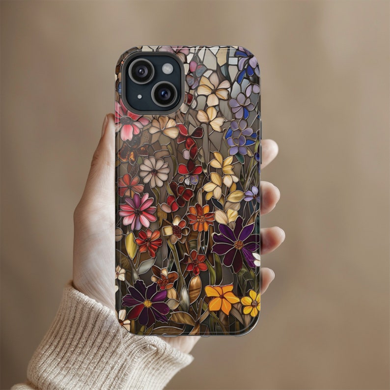 May include: A colourful phone case with a stained glass design of flowers in shades of red, pink, purple, yellow, and green.
