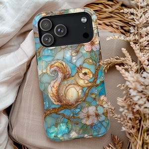 May include: A phone case featuring a detailed illustration of a squirrel perched on a branch with flowers. The design has a stained glass effect with shades of blue, brown, and cream. The case has a black camera module.