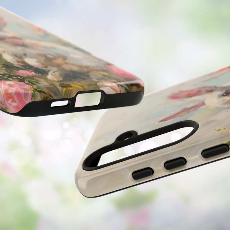 K&ouml;nnte beinhalten: Zwei Handyh&uuml;llen mit unterschiedlichen Blumendesigns. Die obere H&uuml;lle hat einen schwarzen Rand und ein Blumendesign in den Farben Pink, Gr&uuml;n und Braun. Die untere H&uuml;lle hat einen wei&szlig;en Hintergrund mit einem Blumendesign in den Farben Pink, Blau und Wei&szlig;.