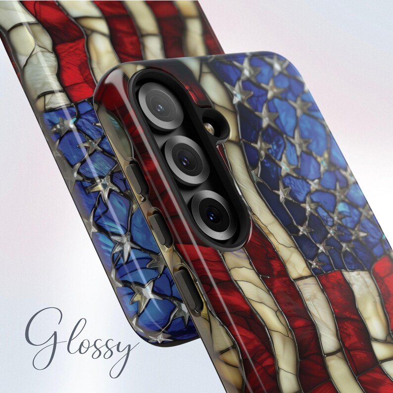 May include: Glossy phone case featuring a stained-glass design of the American flag. The case has a red, white, and blue color scheme with a star pattern in the blue section. The word "Glossy" is written in cursive on the case.