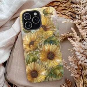 May include: A smartphone case featuring a vibrant sunflower print with yellow petals, dark brown centers, and green leaves. The design has a stained-glass aesthetic with visible outlines. The case has a black camera cutout for a triple-lens system.