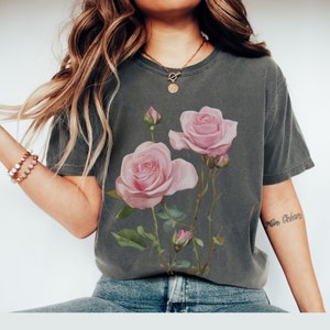 May include: A dark gray t-shirt with a floral print of pink roses and green leaves.